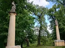 Dvojice sloupů se sochami sv. Vavřince a Nejsvětější Trojice