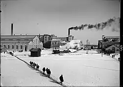 Dělníci odcházejí po cestě ve sněhu