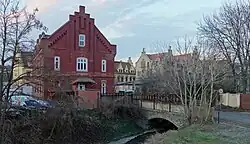 Někdejší zaměstnanecká kolonie Spolku, přelom 19. a 20. století. Vlevo a v pozadí mistrovské domy, vpravo Asylhaus