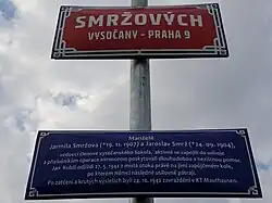 Tabule s názvem ulice Smržových ve Vysočanech s modrou dodatkovou tabulí