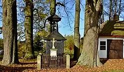 Pod památnými lípami na návsi ve Stružinci dřevěná zvonička (kulturní památka), tzv. Boží muka a pamětní desky na zdi hasičské zbrojnice