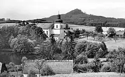 Kostel Nanebevzetí Panny Marie ve Svébořicích,v pozadí je vrch Ralsko