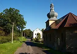 Hlavní silnice ve Svinově, vpravo kaple sv. Floriána, v pozadí stará škola