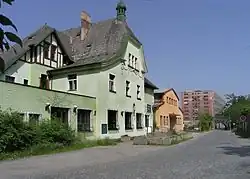Bývalý hotel v Brodcích, v pozadí továrna Jawa
