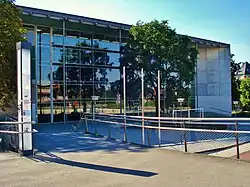 Barevná fotografie s pohledem na prosklené průčelí moderní budovy