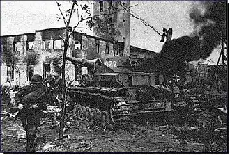 Sovětský voják prochází okolo vyřazeného tanku Panzer IV u Tarnopolu, duben 1944