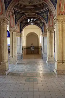 Vestibul nádraží Teplice s klenbami v secesním stylu. Tento prostor stále slouží jako čekárna pro cestující na teplickém nádraží; představený záběr je však postrádá.