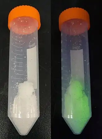 hexahydrát dusičnanu terbitého (vlevo) a luminiscence pod UV světlem (254 nm)