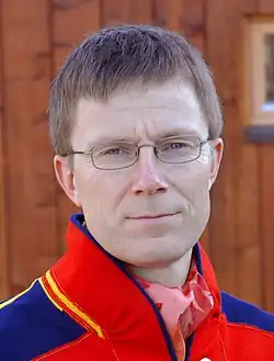 Hlava muže v detailu, s brýlemi v oblečení v sámských barvách