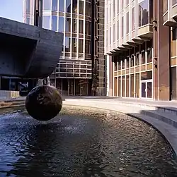 Kašna v areálu Transgasu s dominantní koulí zavěšenou na kovaném řetězu od Ivo Loose