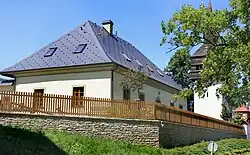 Fara v Trstěnicích, v pozadí zvonice areálu farního kostela.