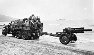 Houfnice M2A1 za tahačem CCKW 352 během operace Torch.