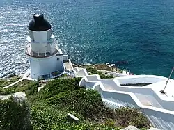 Pohled na pobřeží a maják na ostrově Tung-jin