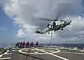 Vrtulník MH-60R ve visu doplňuje palivo z torpédoborce USS Mustin (DDG-89).