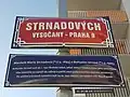Tabule s názvem ulice Strnadových ve Vysočanech s modrou dodatkovou tabulí