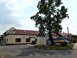 Náves se starou lípou, kapličkou a hostincem U Klimešů