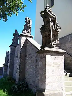 Detail sochy u vstupního schodiště kostela ve Všeni