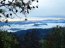 Pohled ze severu na vápencové plošiny Grands Causses; v popředí svědecký vrch u Causse de Sauveterre