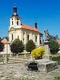 Kostel se studánkou a sochou uprostřed návsi