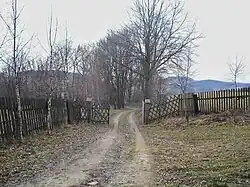 Vjezd do osady koridorem v ohradě obory