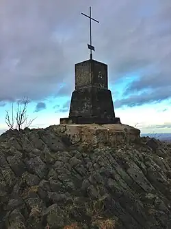 Vrchol kopce s výlevem čediče a křížem