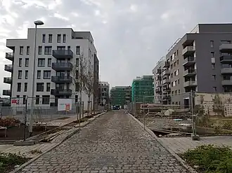 Jižní úsek ulice s rozestavěnými domy, pohled západním směrem