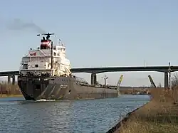 Velká nákladní loď proplouvající kanálem těsně před Garden City Skyway