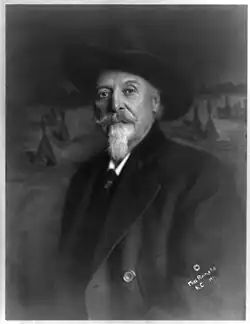 William Frederick Cody, 1846-1917, in front of picture with teepees