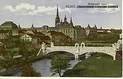 Budova Německého divadla (vlevo) zachycená na pohlednici Plzně z období první republiky