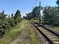 Pohled ze severovýchodního konce nástupiště na trať a železniční most